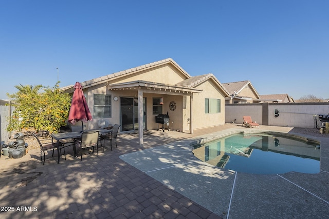 back of property featuring a fenced in pool and a patio