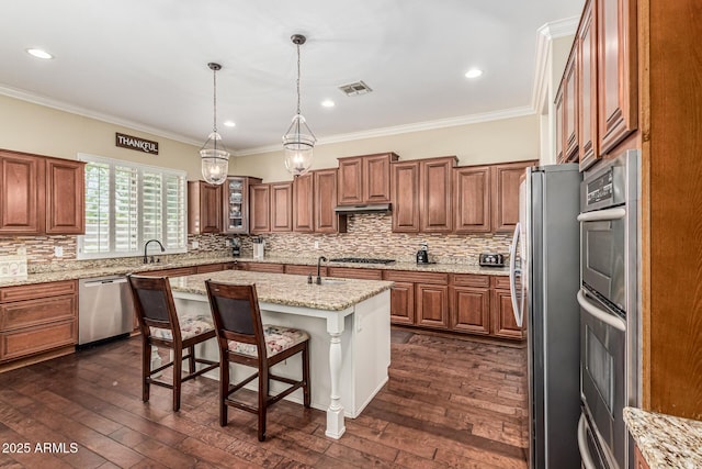 4463 S Oregon Ct, Chandler, AZ 85248 - kitchen with stainless steel appliances, brown cabinetry, a kitchen bar, ornamental molding, and recessed lighting