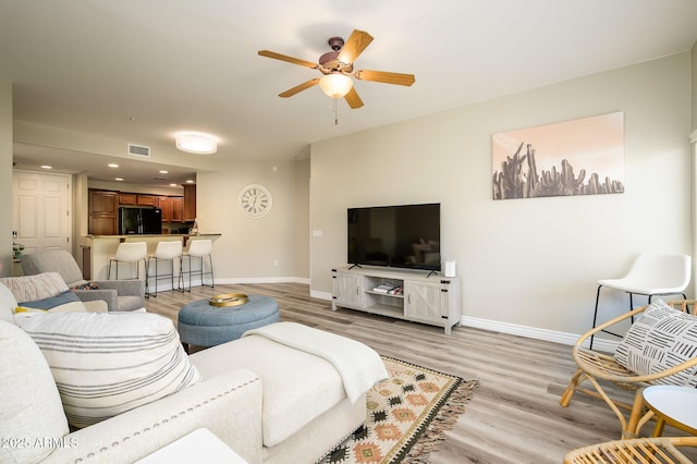 living room with visible vents, baseboards, recessed lighting, ceiling fan, and light wood-style floors