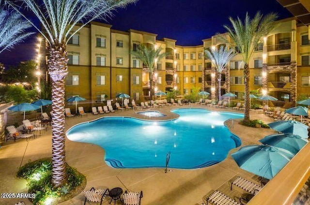 pool at night with a community pool and a patio area