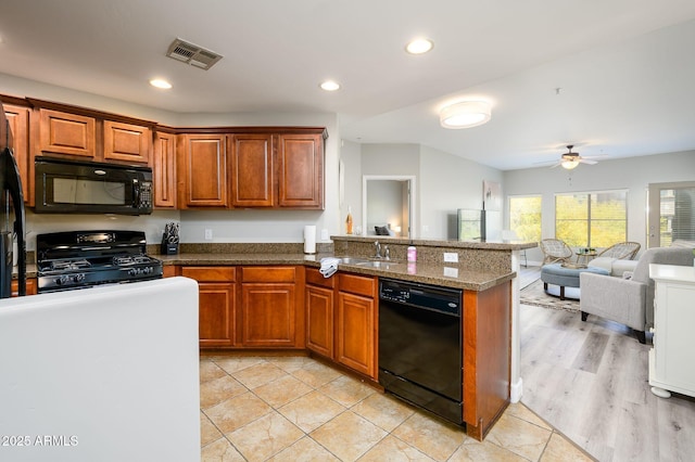 kitchen featuring brown cabinetry, visible vents, a peninsula, and black appliances