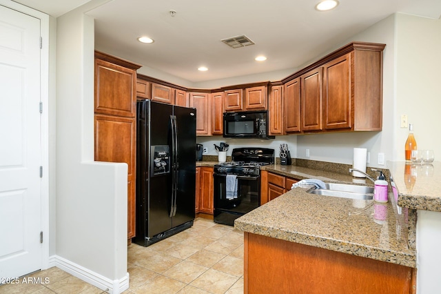 kitchen with black appliances, brown cabinets, visible vents, and a sink