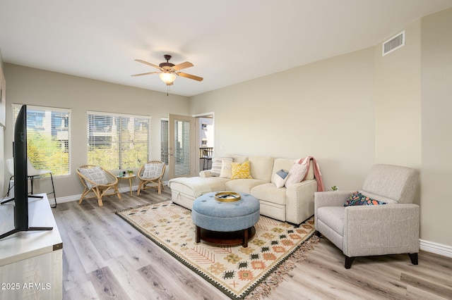 living area with visible vents, baseboards, and wood finished floors