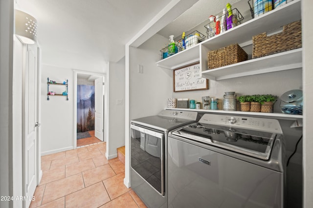 laundry area featuring washer and dryer and light tile patterned floors