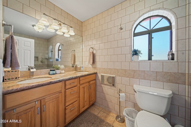 bathroom with tile patterned floors, vanity, tile walls, and toilet