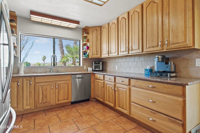 kitchen with decorative backsplash, light tile patterned floors, sink, and appliances with stainless steel finishes