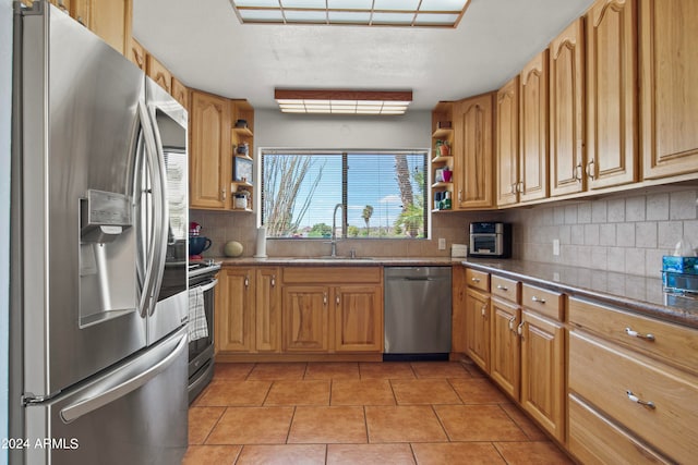 kitchen featuring decorative backsplash, appliances with stainless steel finishes, light tile patterned flooring, and sink