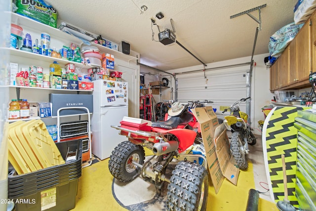 garage with white fridge and a garage door opener