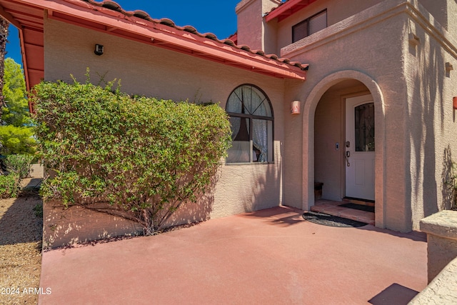 view of exterior entry with a patio