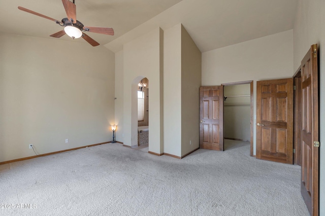 unfurnished bedroom with ceiling fan, high vaulted ceiling, and light carpet