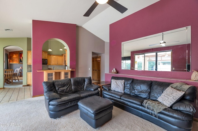 carpeted living room with ceiling fan and lofted ceiling