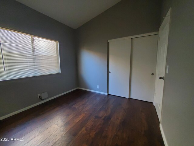 351 S Apache Dr, Chandler, AZ 85224 - unfurnished bedroom featuring dark wood-style floors, vaulted ceiling, a closet, and baseboards