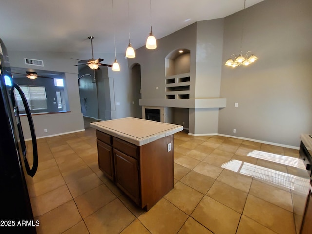 351 S Apache Dr, Chandler, AZ 85224 - kitchen with freestanding refrigerator, built in shelves, light tile patterned floors, and a ceiling fan