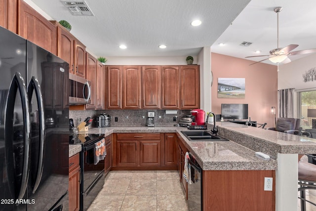 kitchen with a kitchen breakfast bar, kitchen peninsula, sink, black appliances, and lofted ceiling