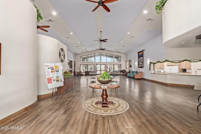 living room with ceiling fan, a high ceiling, and hardwood / wood-style floors