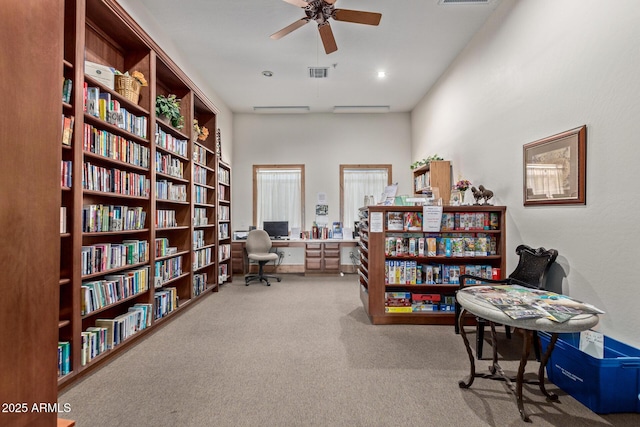 office space with carpet flooring, a towering ceiling, and ceiling fan