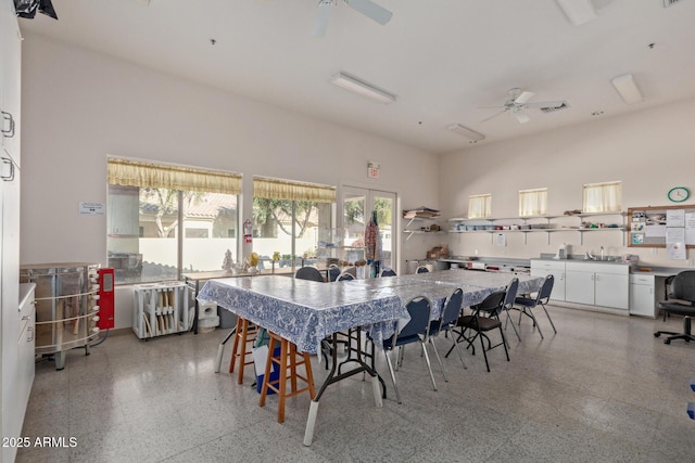 dining area featuring sink, a towering ceiling, and ceiling fan