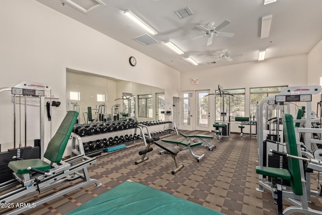 workout area with a towering ceiling and ceiling fan