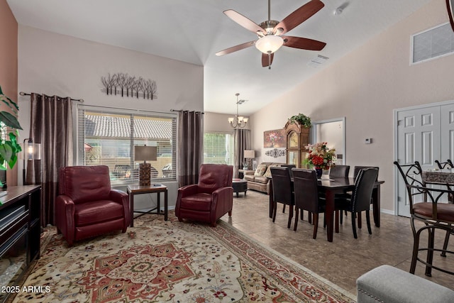 living room with ceiling fan with notable chandelier and high vaulted ceiling