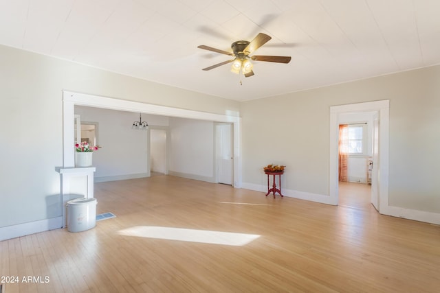 empty room featuring a ceiling fan, light wood-type flooring, and baseboards