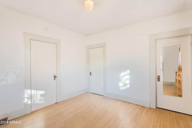 spare room featuring baseboards and hardwood / wood-style flooring