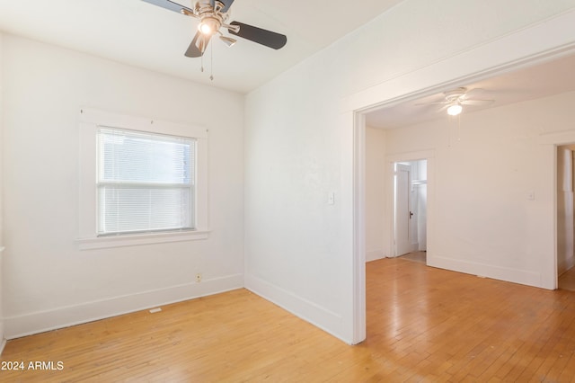 unfurnished room with ceiling fan, baseboards, and light wood-style flooring