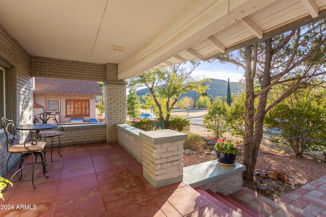 view of patio with a porch and a mountain view