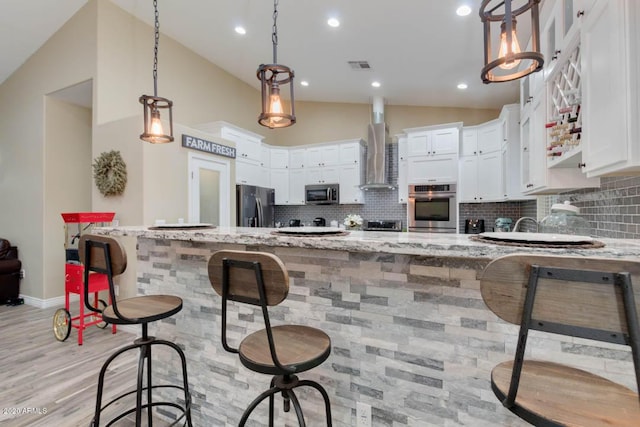 1101 S 4th St, Avondale, AZ 85323 - kitchen featuring appliances with stainless steel finishes, wall chimney range hood, lofted ceiling, a peninsula, and decorative backsplash