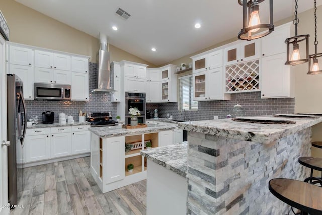 1101 S 4th St, Avondale, AZ 85323 - kitchen with a kitchen island, wall chimney range hood, appliances with stainless steel finishes, vaulted ceiling, and open shelves