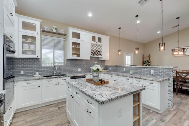 1101 S 4th St, Avondale, AZ 85323 - kitchen featuring a peninsula, open shelves, tasteful backsplash, light wood-style flooring, and vaulted ceiling