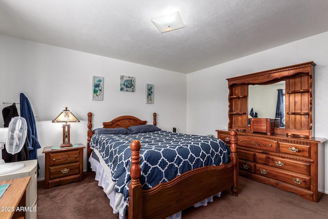 bedroom with dark carpet and a textured ceiling