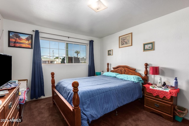 bedroom with dark colored carpet and a textured ceiling