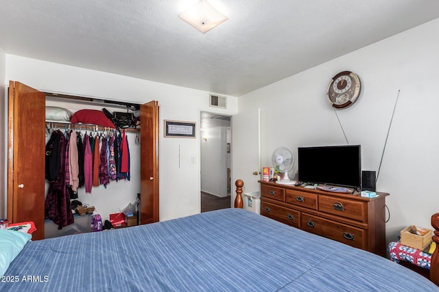 bedroom with a textured ceiling, visible vents, and a closet