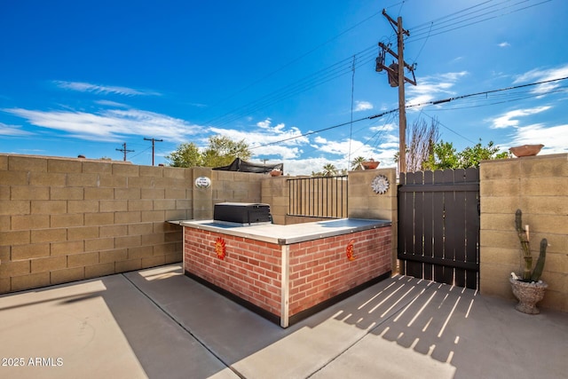 view of patio featuring fence and a gate