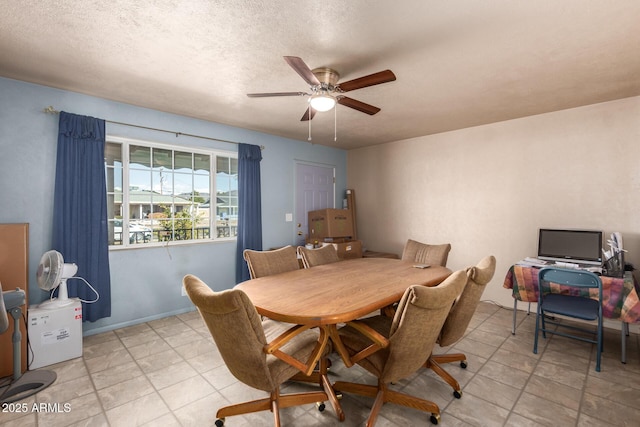 dining space featuring ceiling fan and a textured ceiling