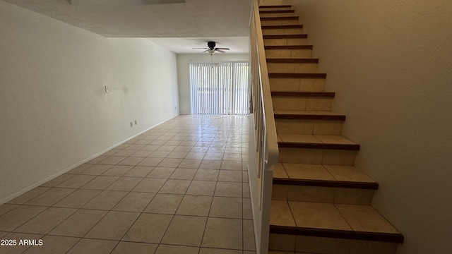 staircase featuring ceiling fan