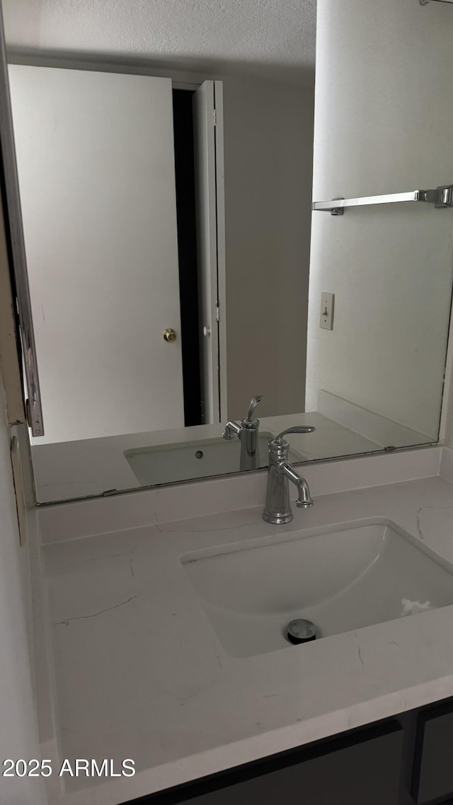 bathroom featuring a textured ceiling and vanity