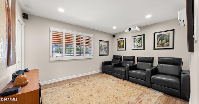 home theater with light wood-type flooring and a wall mounted air conditioner