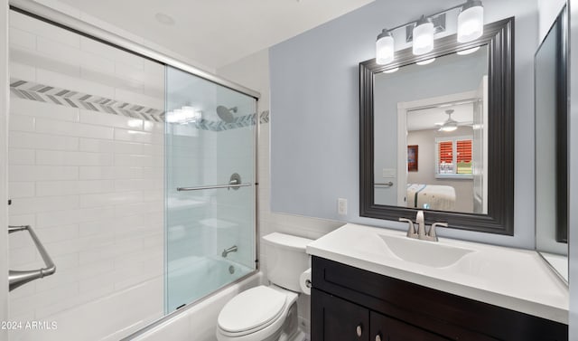 full bathroom with vanity, toilet, ceiling fan, and enclosed tub / shower combo