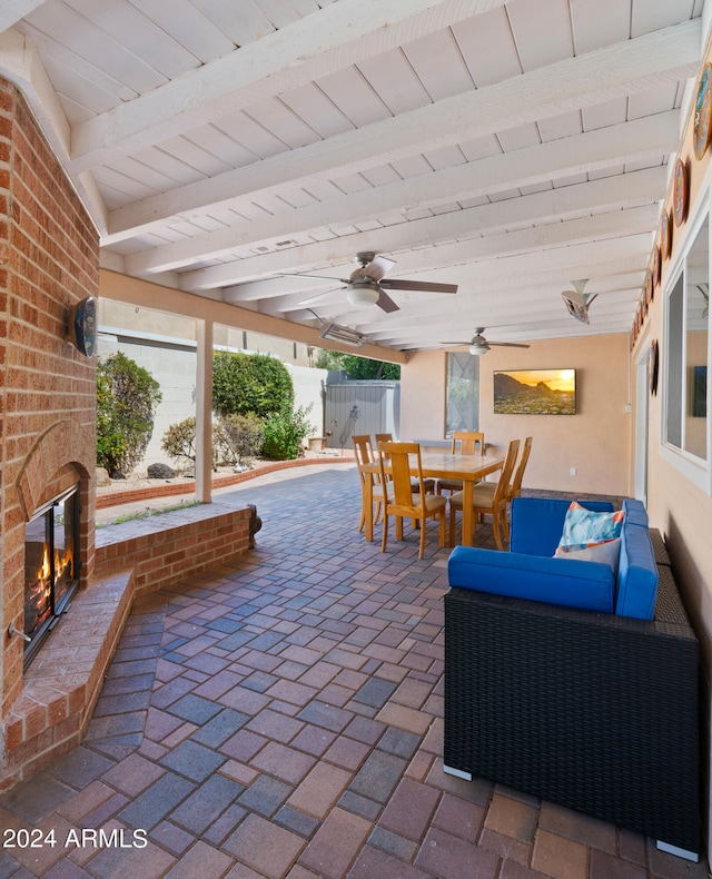 view of patio featuring an outdoor brick fireplace and ceiling fan