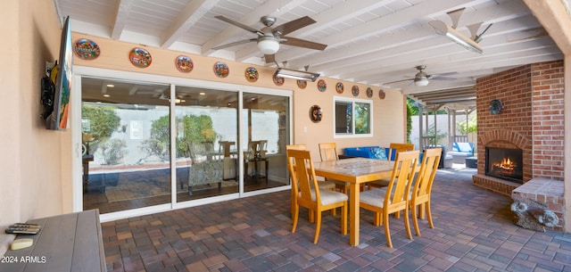 interior space featuring ceiling fan, an outdoor brick fireplace, wood ceiling, and beamed ceiling