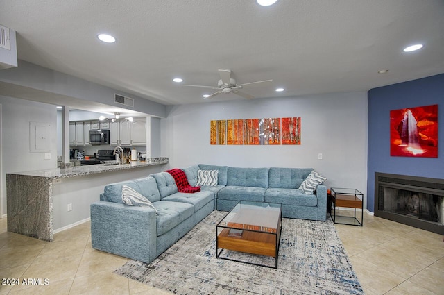 tiled living room featuring a textured ceiling and ceiling fan