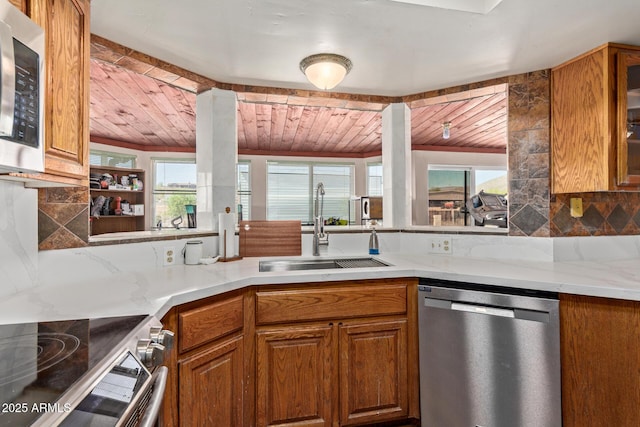 1024 E Saddle Mountain Rd, Phoenix, AZ 85086 - kitchen featuring stainless steel appliances, a sink, wood ceiling, brown cabinetry, and glass insert cabinets