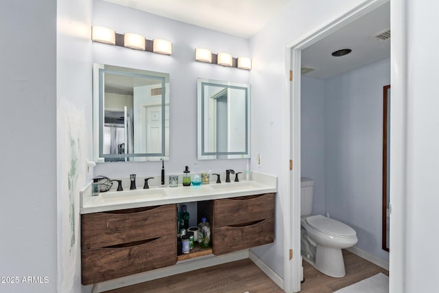1024 E Saddle Mountain Rd, Phoenix, AZ 85086 - bathroom featuring wood finished floors, toilet, double vanity, and baseboards