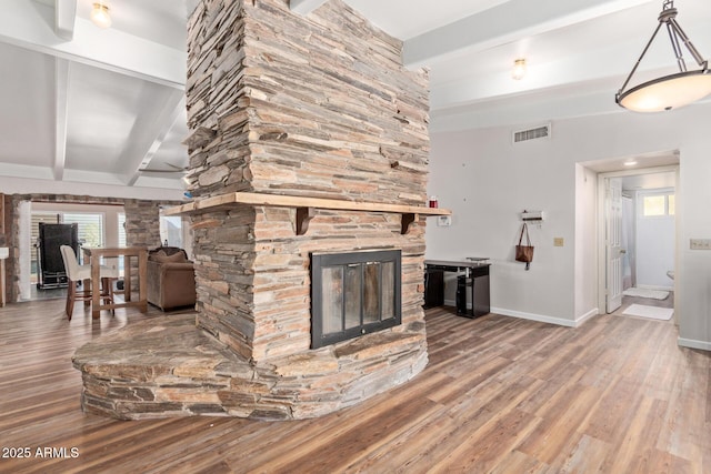 1024 E Saddle Mountain Rd, Phoenix, AZ 85086 - living area with beamed ceiling, a stone fireplace, wood finished floors, healthy amount of natural light, and baseboards
