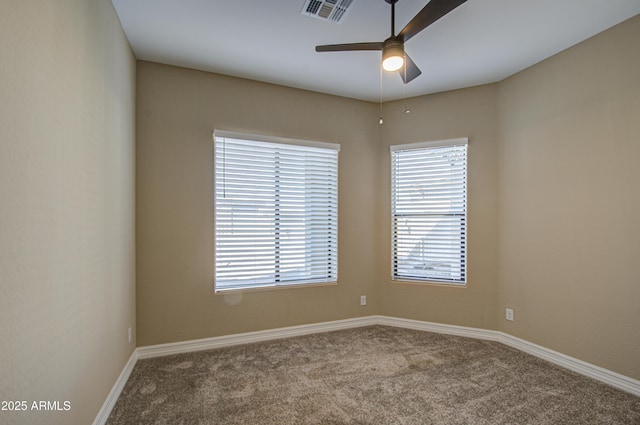 unfurnished room with carpet floors, baseboards, visible vents, and a ceiling fan