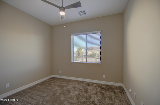 carpeted spare room with ceiling fan, visible vents, and baseboards