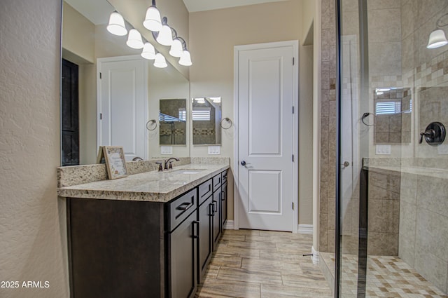 full bathroom featuring a stall shower, baseboards, and vanity