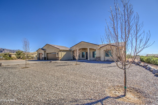 view of front of property with driveway, an attached garage, and stucco siding