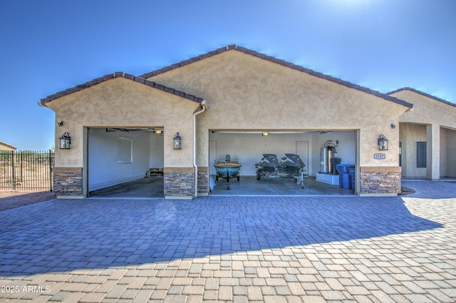 garage featuring decorative driveway and fence